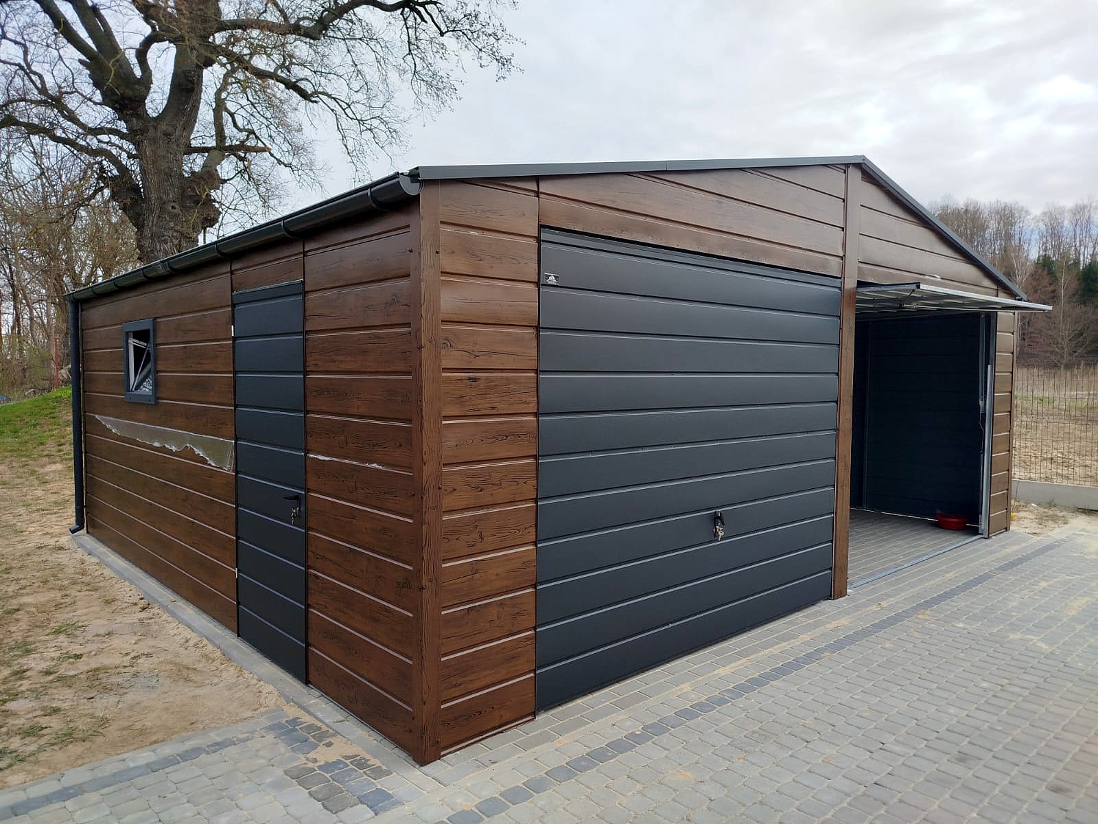 Garaż blaszany 7x6 - Dwustanowiskowy, Dach dwuspadowy, Kolor drewnopodobny orzech, Bramy uchylne Garaż blaszany 7x6 - Dwustanowiskowy, Dach dwuspadowy, Kolor drewnopodobny orzech, Bramy uchylne