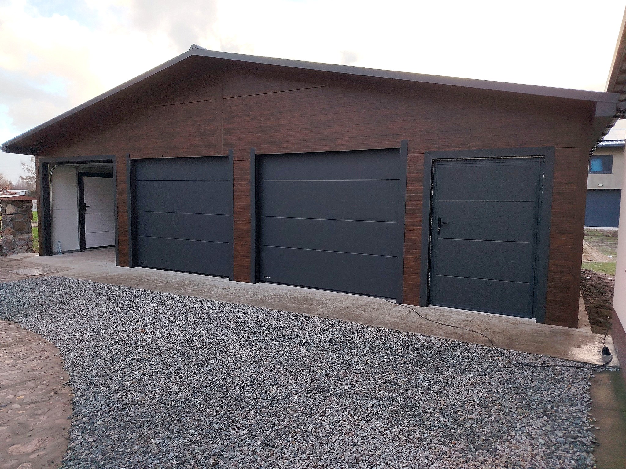 Garaż z płyty warstwowej 10x6 -Dach dwuspadowy, Ocieplany, Kolor drewnopodobny orzech, Brama Segmentowa, Drzwi wejściowe Garaż z płyty warstwowej 10x6 -Dach dwuspadowy, Ocieplany, Kolor drewnopodobny orzech, Brama Segmentowa, Drzwi wejściowe