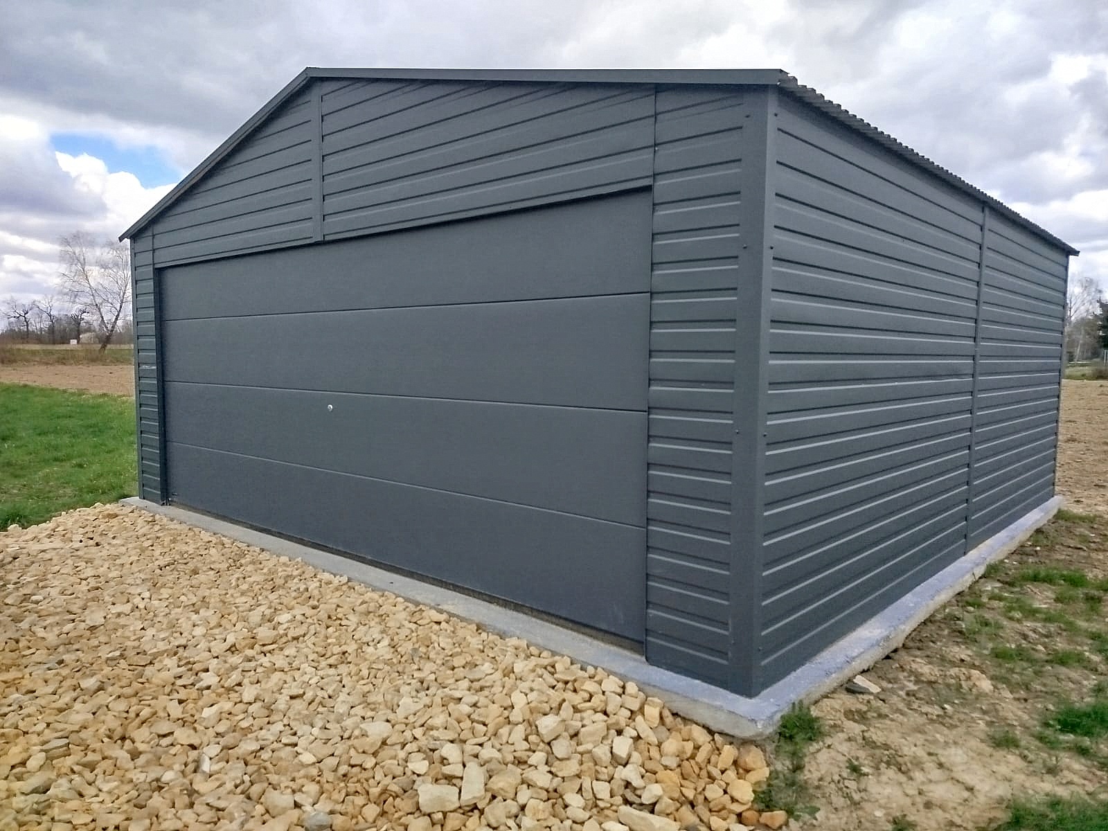 Garaż blaszany 6x6 - Dwustanowiskowy, Dach dwuspadowy, Kolor antracyt, Brama segmentowa Garaż blaszany 6x6 - Dwustanowiskowy, Dach dwuspadowy, Kolor antracyt, Brama segmentowa