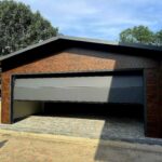 Garaż z płyty warstwowej 6x6 - Dach dwuspadowy, Ocieplany, Kolor drewnopodobny orzech, Brama segmentowa, Drzwi wejściowe