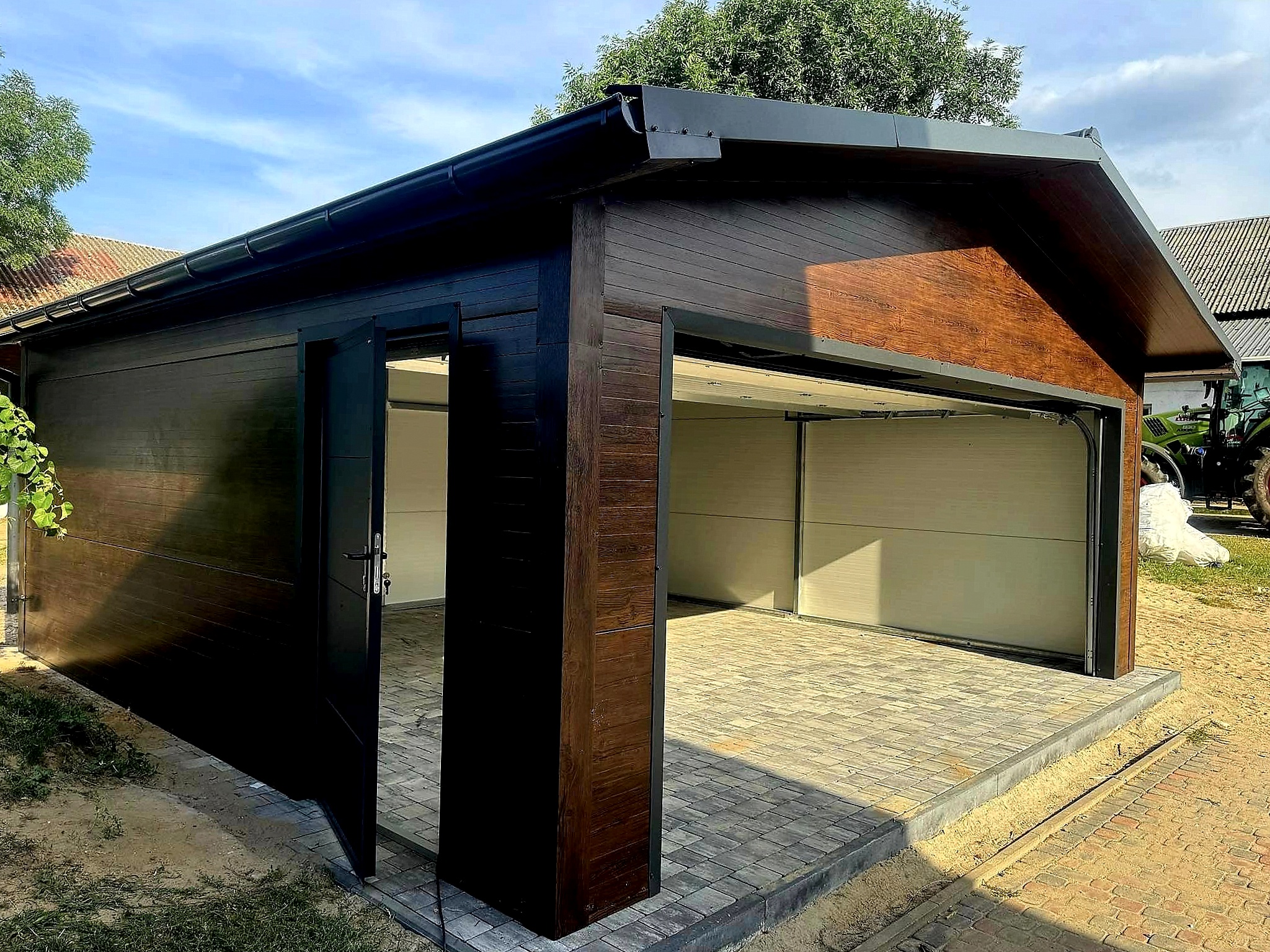 Garaż z płyty warstwowej 6x6 - Dach dwuspadowy, Ocieplany, Kolor drewnopodobny orzech, Brama segmentowa, Drzwi wejściowe Garaż z płyty warstwowej 6x6 - Dach dwuspadowy, Ocieplany, Kolor drewnopodobny orzech, Brama segmentowa, Drzwi wejściowe